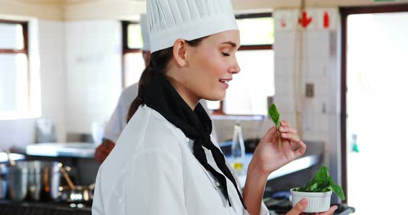 Smiling chef smelling herbs in kitchen