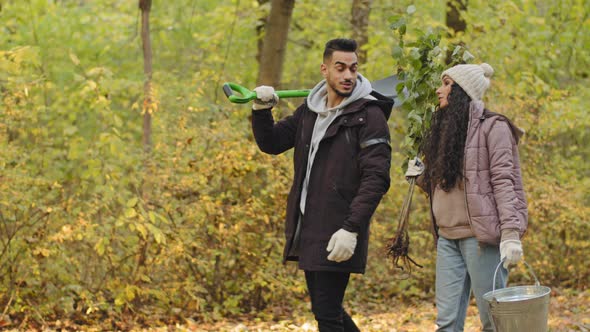 Happy Couple Young People Eco Activists Volunteers Walking in Autumn Park Talking Choose Suitable