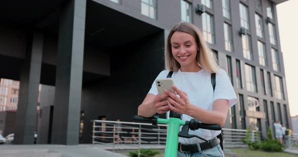 Portrait of attractive woman using alternative electric scooter in the city.