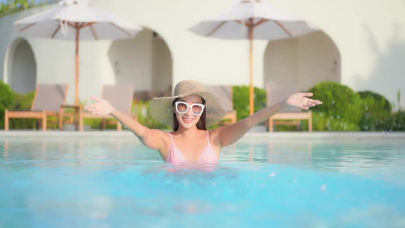 Young asian woman enjoy around outdoor swimming pool for leisure