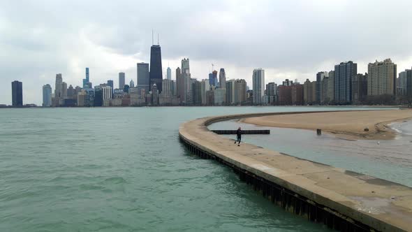 lifestyle fitness and sports person running in lake shore of lake michigan in chicago aerial footage