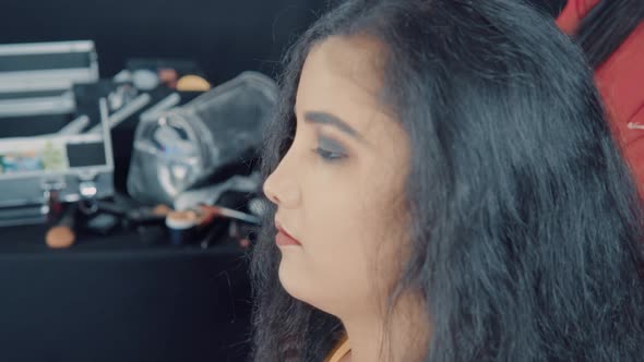 Close up of young beautiful woman in cosmetics studio making a hairstyle