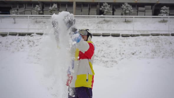 A Young Man in a Park Throws Snow u Into the Air. Slowmotion Shot