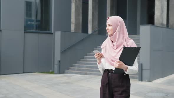 Muslim Business Woman in Formal Clothes and Hijab Standing on Street and Talking