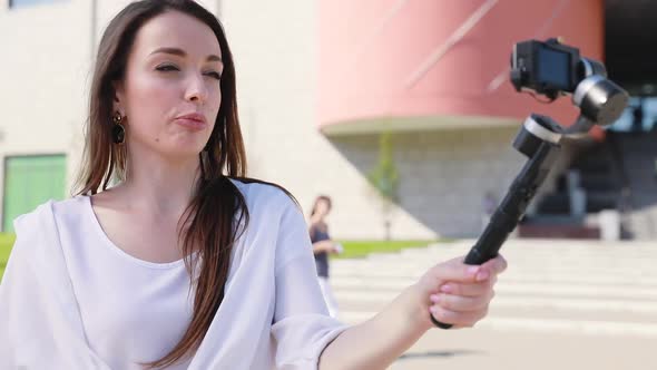 Blogging. Woman filming video on camera on street