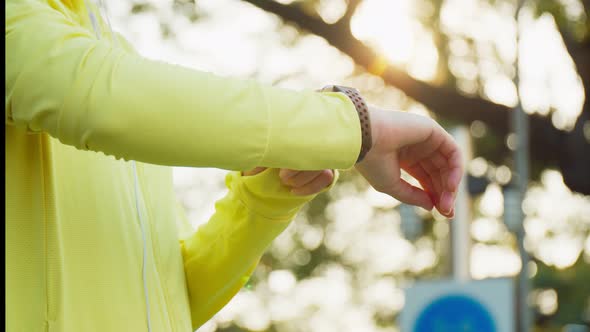 Close-up athletic woman measuring heart rate on a smartwatch while resting after running.