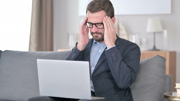 Young Businessman with Laptop Having Headache at Home 