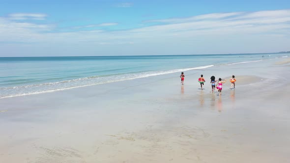 4K Group of Diversity children playing on tropical beach together on summer vacation at the sea