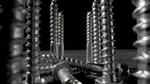 Screws Metal Threaded Bolts Fasteners on Table on Isolated Black Background