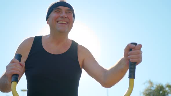 An Elderly Man Performs an Exercise on an Orbit Track.