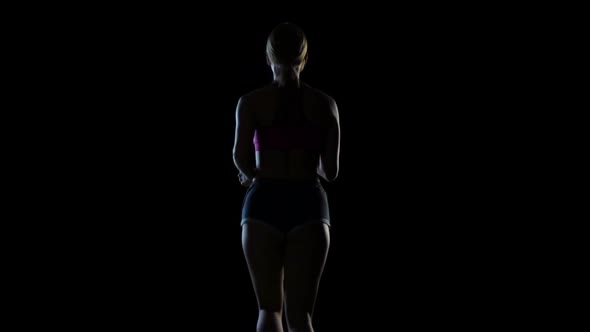 View From the Back on a Woman Running on a Black Screen. Silhouette. Slow Motion