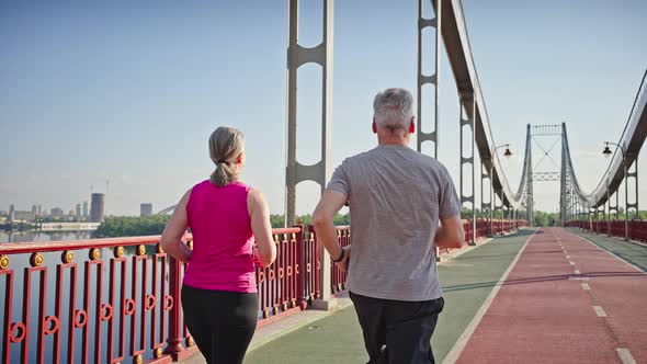 Sportive Pensioners Take Care of Body Running on Bridge