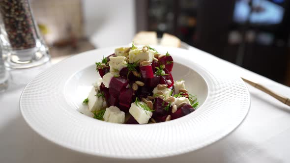 Healthy salad with beetroot, feta cheese and sunflower seeds in white plate