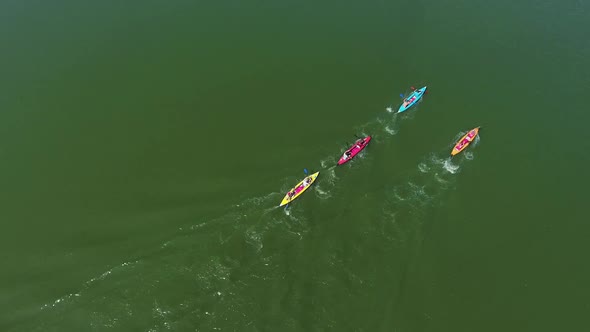 Aerial Top Down of Kayakers Competing on Dark Green River Surface