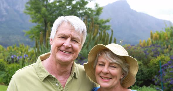 Smiling senior couple standing together in garden