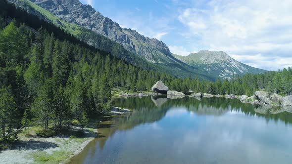 Moving Forward to Clear Blue Lake and Pine Woods Forest Mountain Valley in Summer