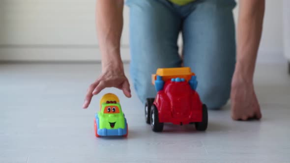 An adult man is playing with a toy car on the floor. Concept of nostalgia for childhood