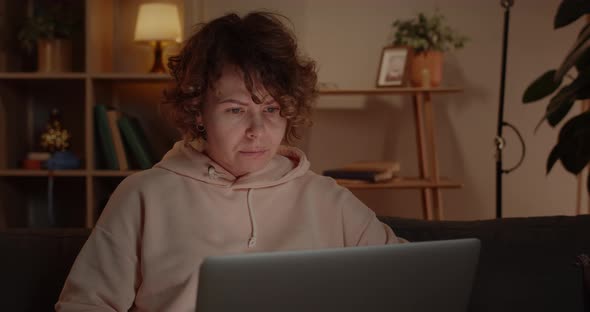 Crop View of Beautiful Woman Using Laptop While Sitting on Sofa at Home