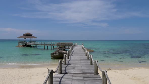 Wide shot POV Walking on wooden footbridge that leads to the sea. Koh Kood, Thailand. SLOW MOTION