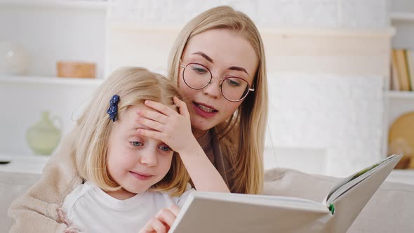 Portrait Caucasian Mother in Glasses Reads Book Fairy Tale to Child Little Daughter Teaches Baby at