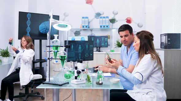 Female Biologist Working Next To Her Assistant