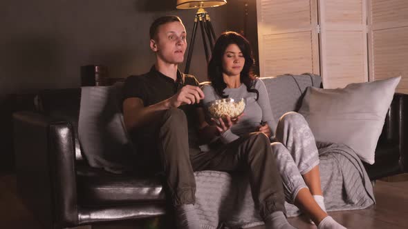 Young Couple Watching Horror on Tv at Home. Reacting on Screamer