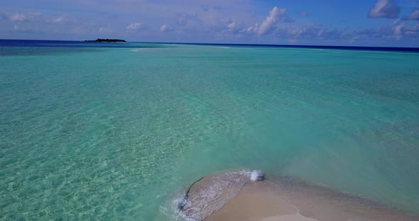 Natural birds eye island view of a sandy white paradise beach and turquoise sea background in 4K