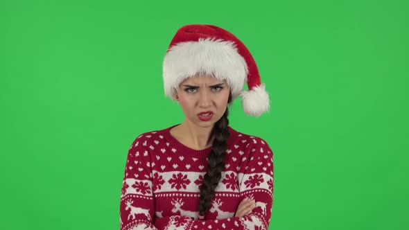 Portrait of Sweety Girl in Santa Claus Hat Annoyed Gesturing in Stress Expressing Irritation. Green