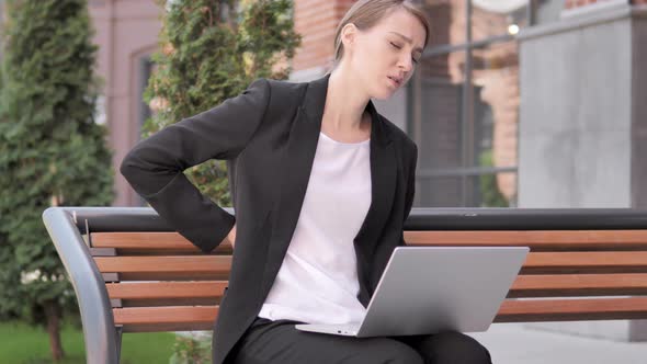 Young Businesswoman with Back Pain Working on Laptop Outdoor