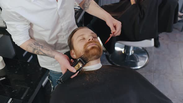 Confident Bearded Man in Barbershop Trimming Beard