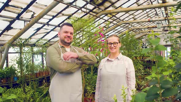 Portrait of a Young Couple of Farmers Standing in Front of the Camera in a Greenhouse