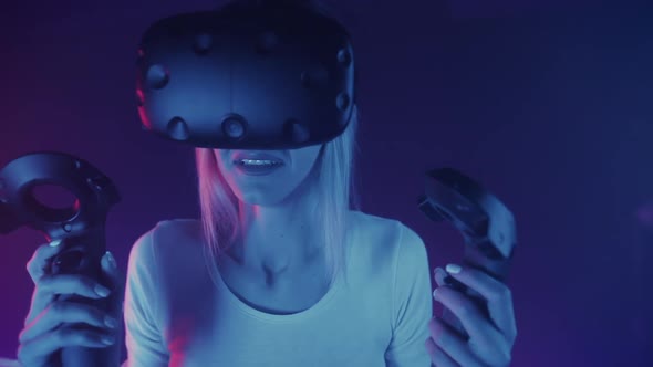 Young Caucasian Girl in Virtual Reality Glasses Holding Controllers Looking Scared and Upset