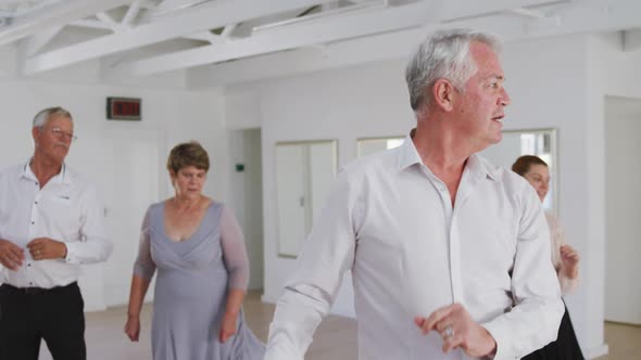 Caucasian senior couple spending time together dancing in a ballroom