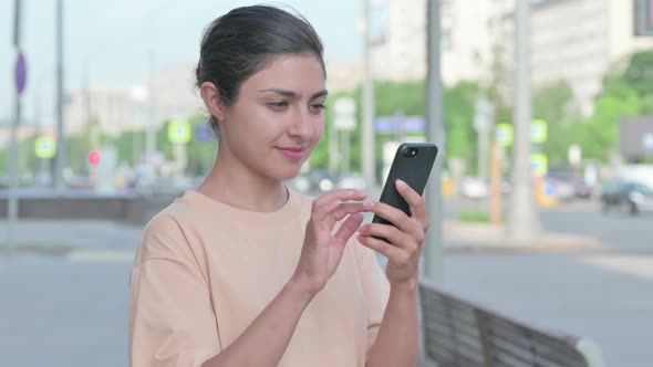 Indian Woman Celebrating Online Success on Smartphone