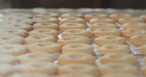 Baker preparing butter cookies with strawberry jam and powdered sugar