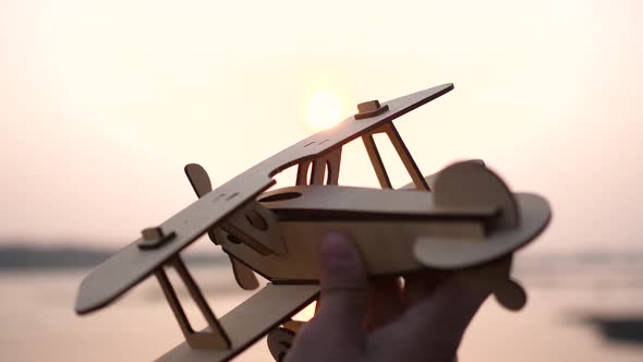 the Child Holds a Plane in His Hand Against the Setting Sun Simulates the Flight