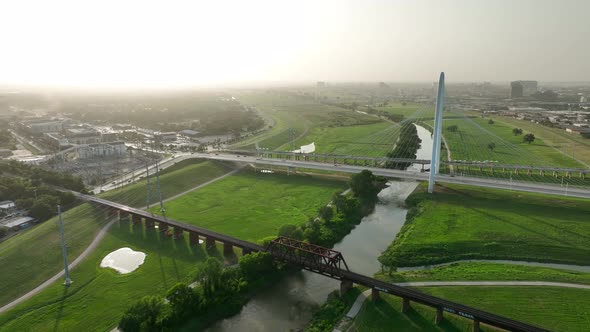 Margaret Hunt Hill Bridge during dramatic sunset golden hour light. Aerial over Trinity River in Dal