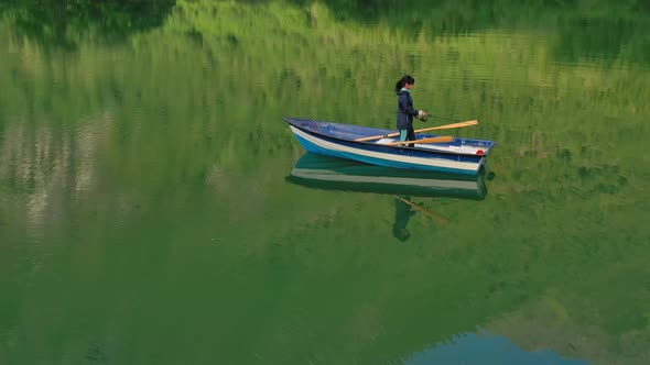 Woman on the Boat Catches a Fish on Spinning in Norway