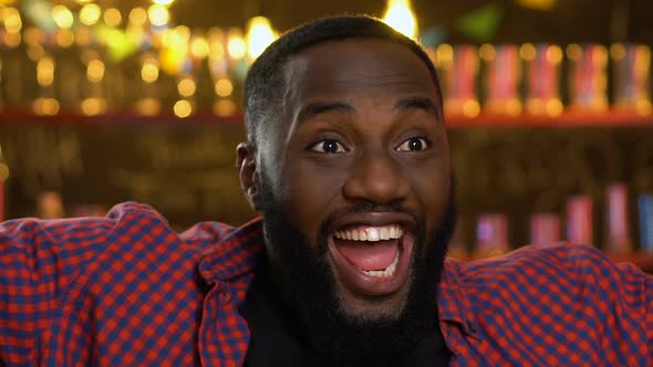 Happy Afro-American Sports Fan Watching Match in Pub, Celebrating Team Victory