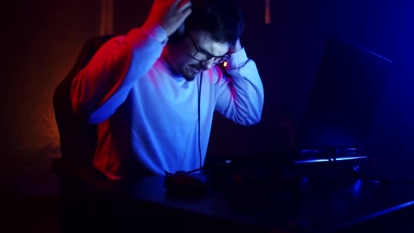Angry Male Gamer Rips Headphones Off Head and Screams with Clenched Fists at Laptop Screen After