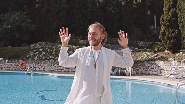 Young Man In White Robes Dancing By Swimming Pool
