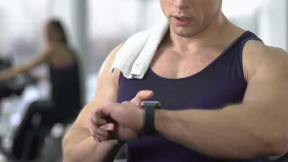 Sportive Man Checking Pulse in Smartwatch After Gym Workout, Fitness Technology