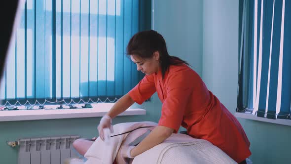 Woman Prepares Client with Stretch Marks for Myostimulation