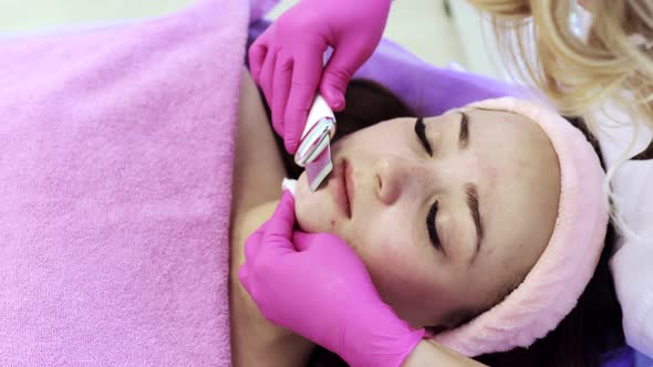 Ultrasonic scrabbing. Young woman receiving ultrasound cavitation facial peeling cleansing