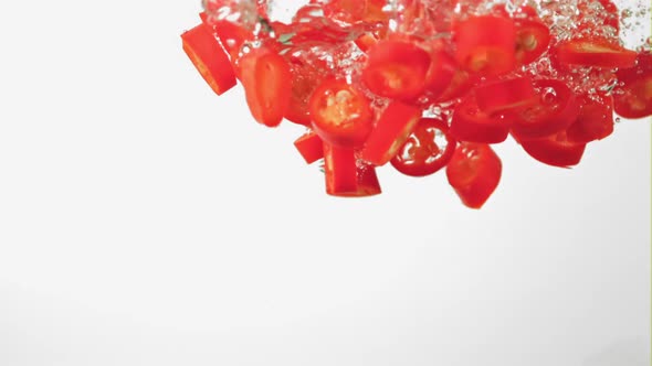 Super Slow Motion Chopped Chilli Pepper Under Water with Air Bubbles