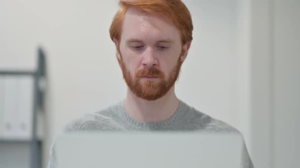 Portrait of Young Redhead Man Using Laptop 