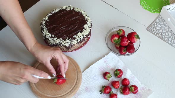A Woman Cuts A Strawberry. For Cake Decorating.