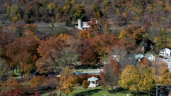 Aerial dolly move past the Berkeley Springs State Park showing the castle on the hill above, Roman B