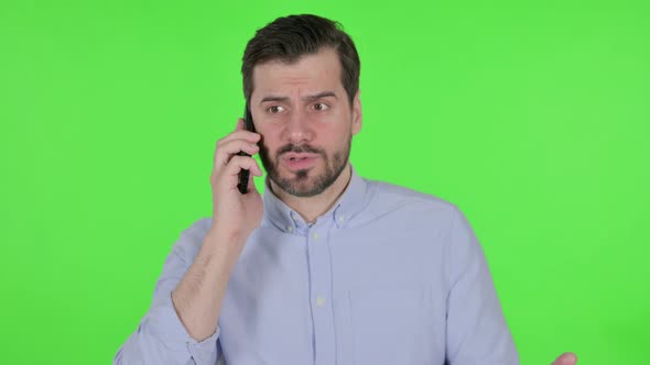 Portrait of Man Talking Angrily on Smartphone Green Screen