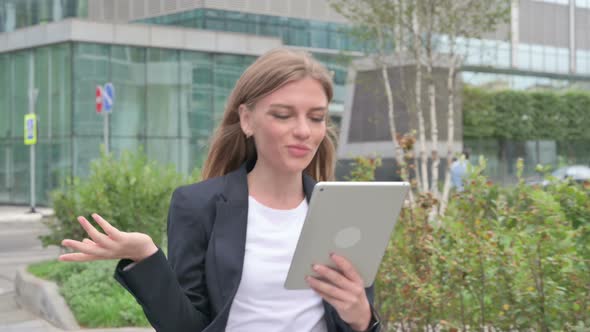 Young Businesswoman Talking on Video Call on Tablet While Walking on the Street